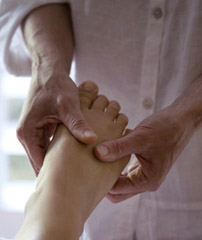 foot in hand of practitioner - a reflexologist